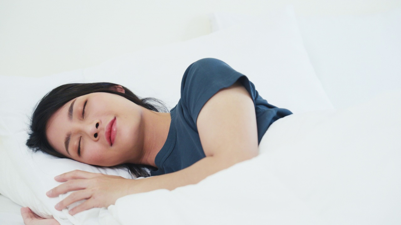 女人睡在舒适的床上视频素材