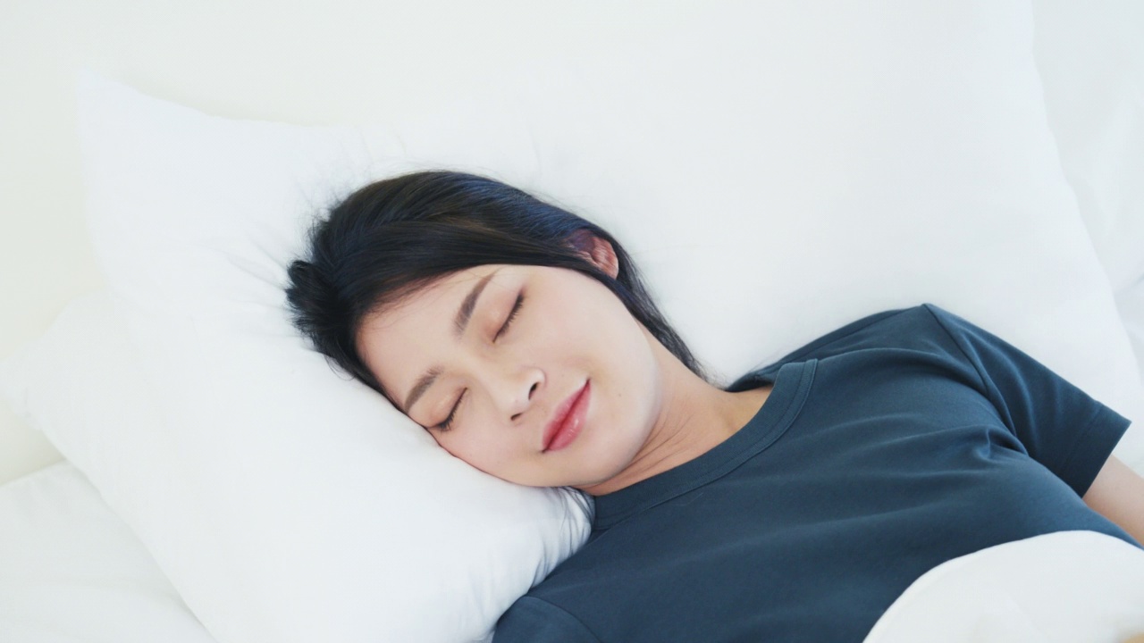 女人睡在舒适的床上视频素材