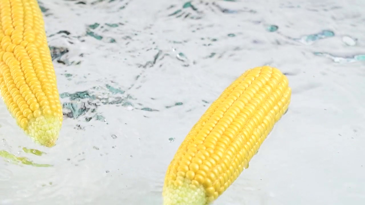 新鲜生玉米芯落在白色湿面上溅起水花视频下载