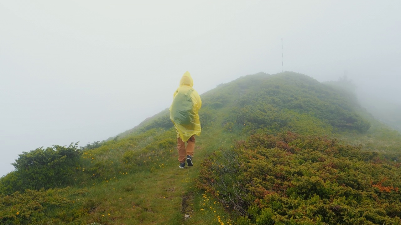 沉闷的风景和穿黄雨衣的女人没有风景在山里。视频素材