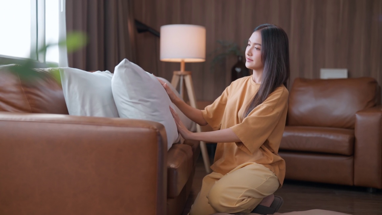 家庭主妇家庭工作的家务保持概念，亚洲女性在休闲布妇女安排坐垫在家里，家庭，家庭改善和清洁概念-妇女安排靠垫在扶手椅和sof视频素材