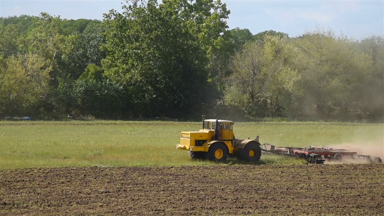 拖拉机在土地上耕作。视频下载