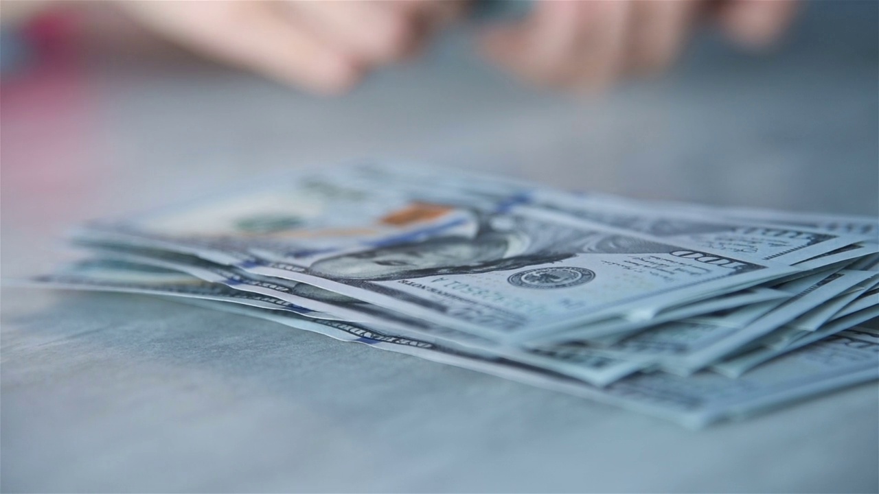 女人的手在桌子上数美元钞票视频下载