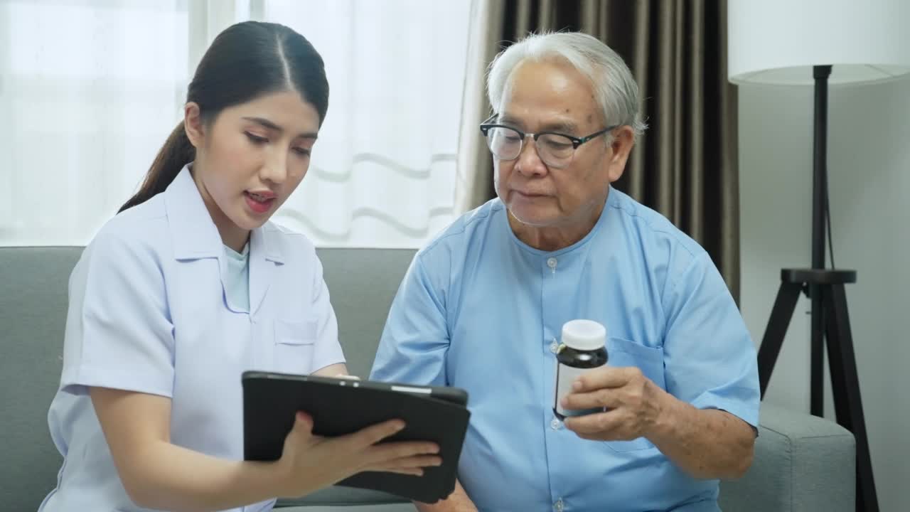 女医生/家庭保健护士或物理治疗师拿着数字平板与老年患者交谈，讨论处方药物。视频素材