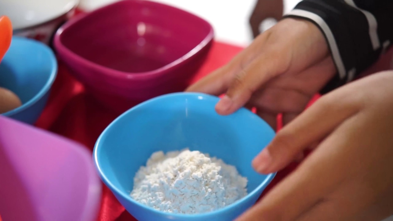 倒面粉特写。把白面粉从小碗倒到大碗里视频素材