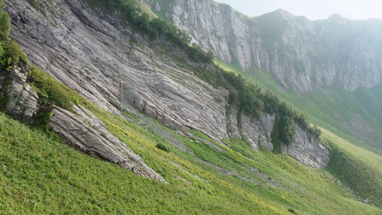 山谷中陡峭的悬崖上长满了茂盛的草和灌木视频素材