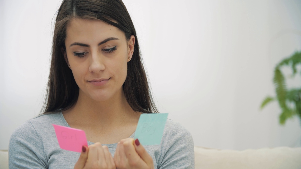 年轻孕妇度假的4k慢动作视频蓝色和粉色贴纸。视频下载