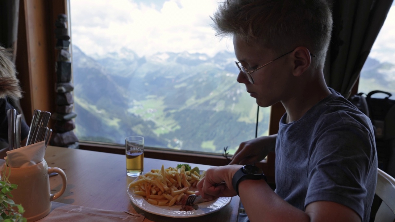 十几岁的男孩在餐厅享用午餐视频素材