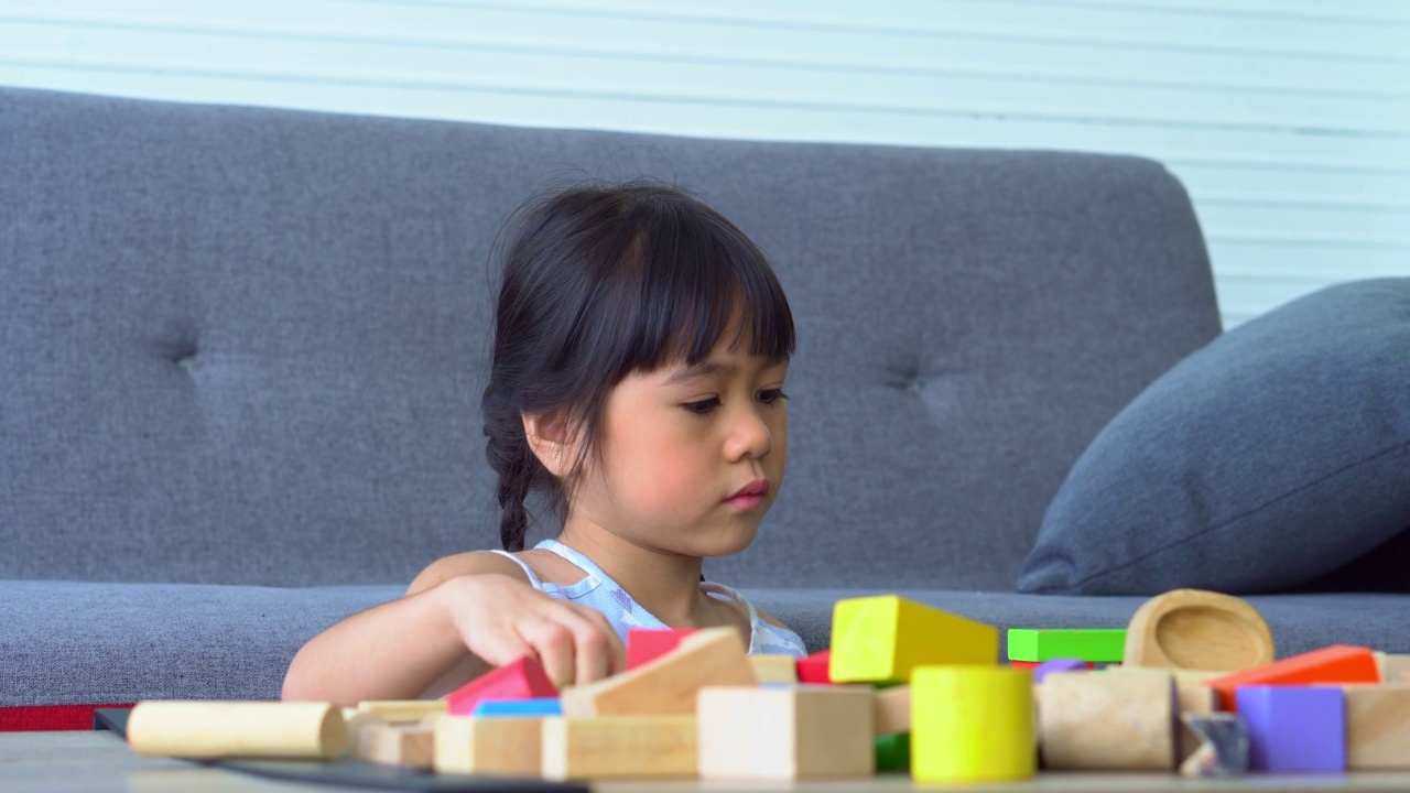 可爱的亚洲小女孩玩五颜六色的玩具块，孩子们在幼儿园或日托所玩教育玩具。幼儿发展理念的创造性游戏，幼儿托儿所的幼儿。视频素材