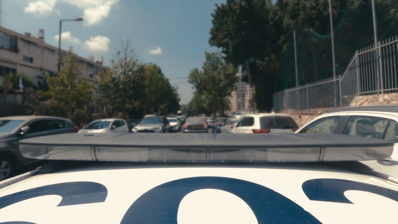 一辆带着蓝色和红色灯的警车在城市街道上快速行驶视频素材