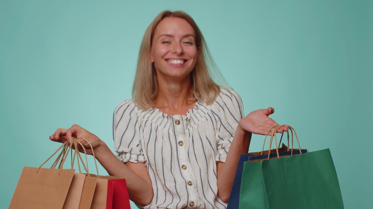 快乐的女游客展示着购物袋，广告假期打折，惊叹于低廉的价格视频素材