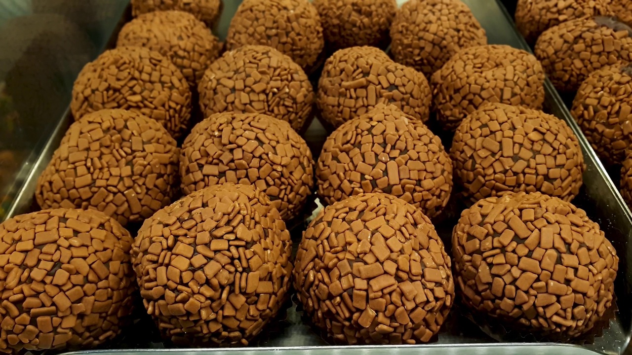 几个巴西巧克力软糖球(brigadeiros)在巴西面包店橱窗的特写。视频素材