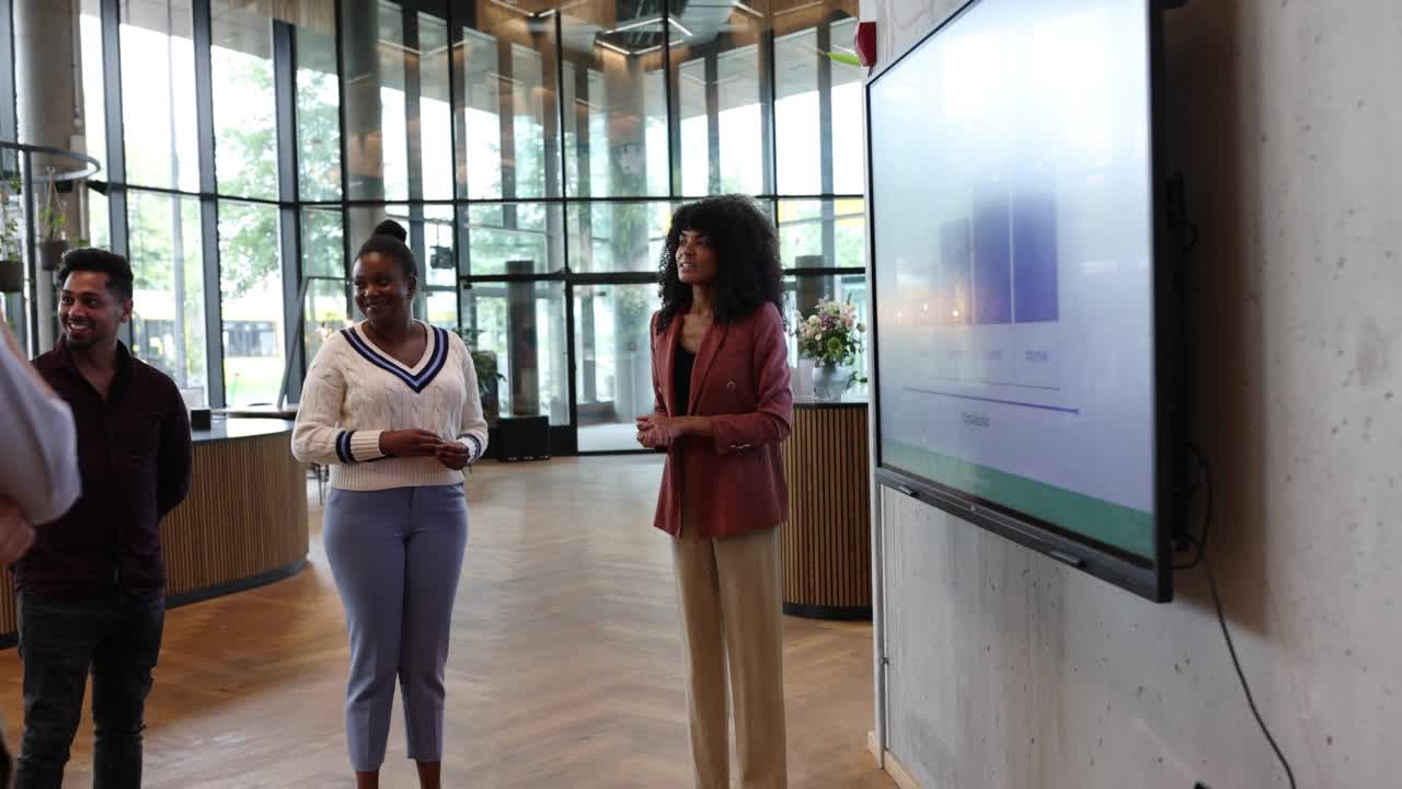 女商人在办公室与团队在大电视屏幕上分享项目细节视频素材