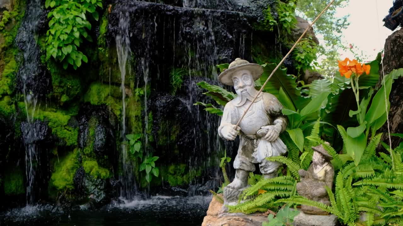 禅宗花园中带池塘的渔夫雕像视频下载