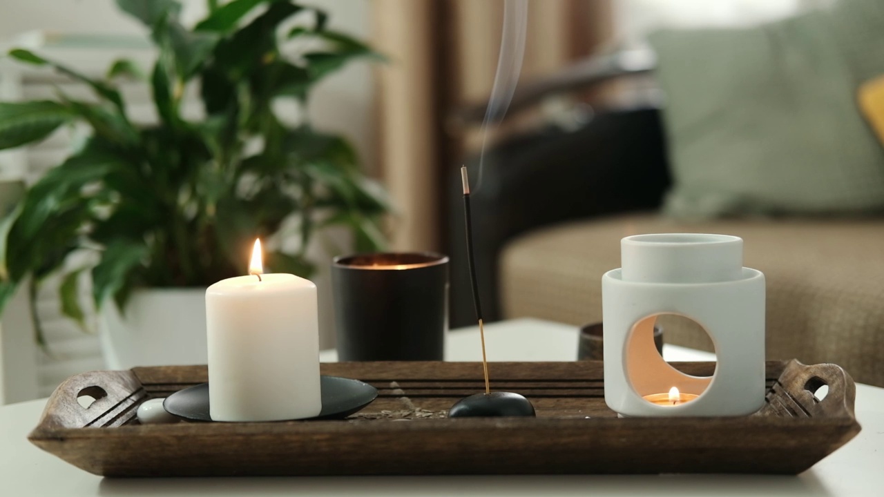 客厅桌子上燃着香薰蜡烛和香薰香棒、香薰灯。芳香疗法,香味。家庭放松和抗压力的概念。视频下载