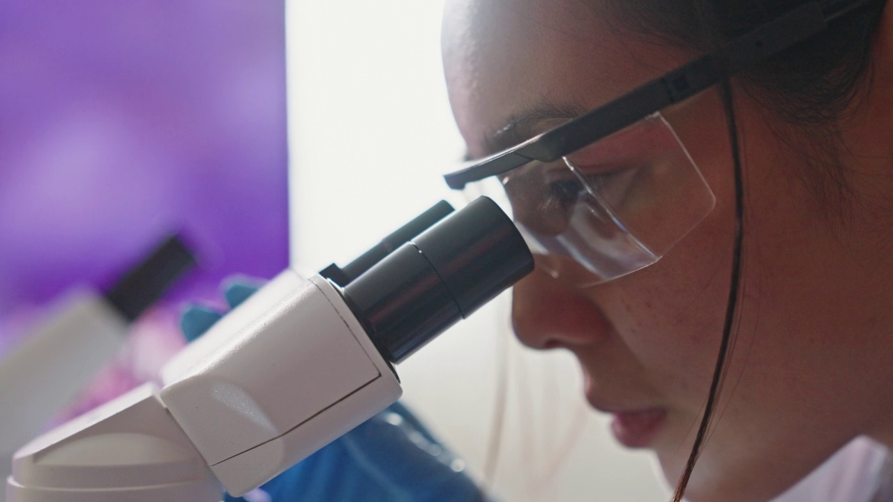 医学实验室科学家在实验室显微镜下观察视频素材