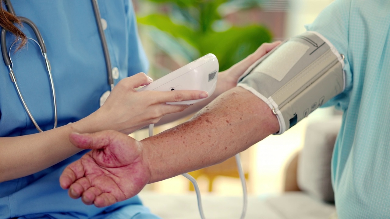 护士在老人手臂上使用自动手持血压测量的特写。视频素材