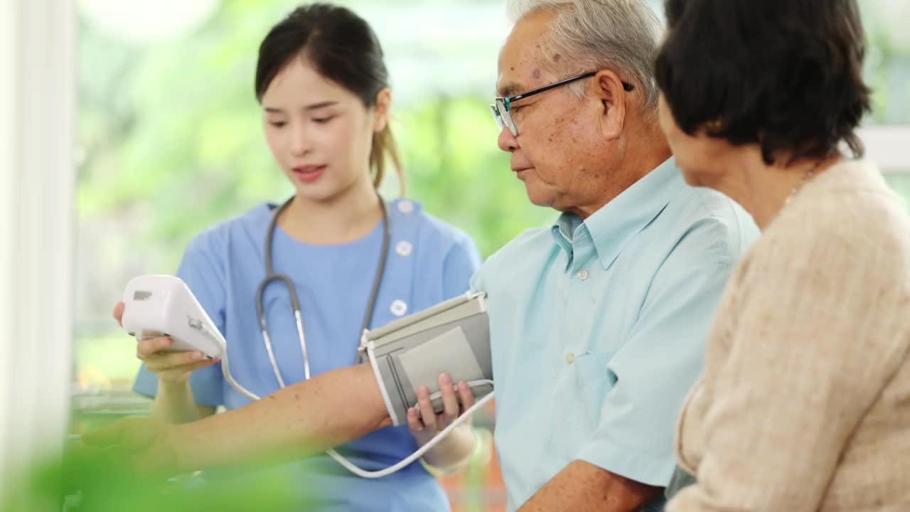 护士在老年人手臂上使用自动手持血压测量仪。视频素材