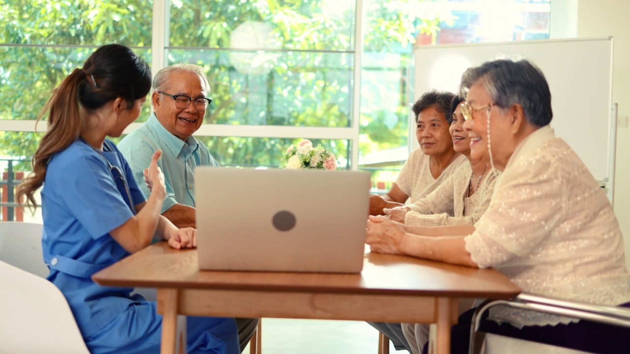 年轻的亚洲女护士用笔记本电脑给老年人提供友好的咨询演示视频素材