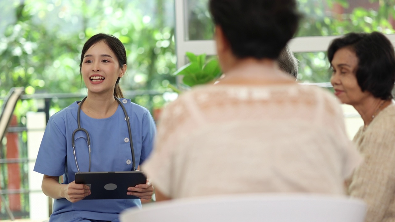 年轻的亚洲女护士用药片友好地为老年群体提供保健咨询。视频素材