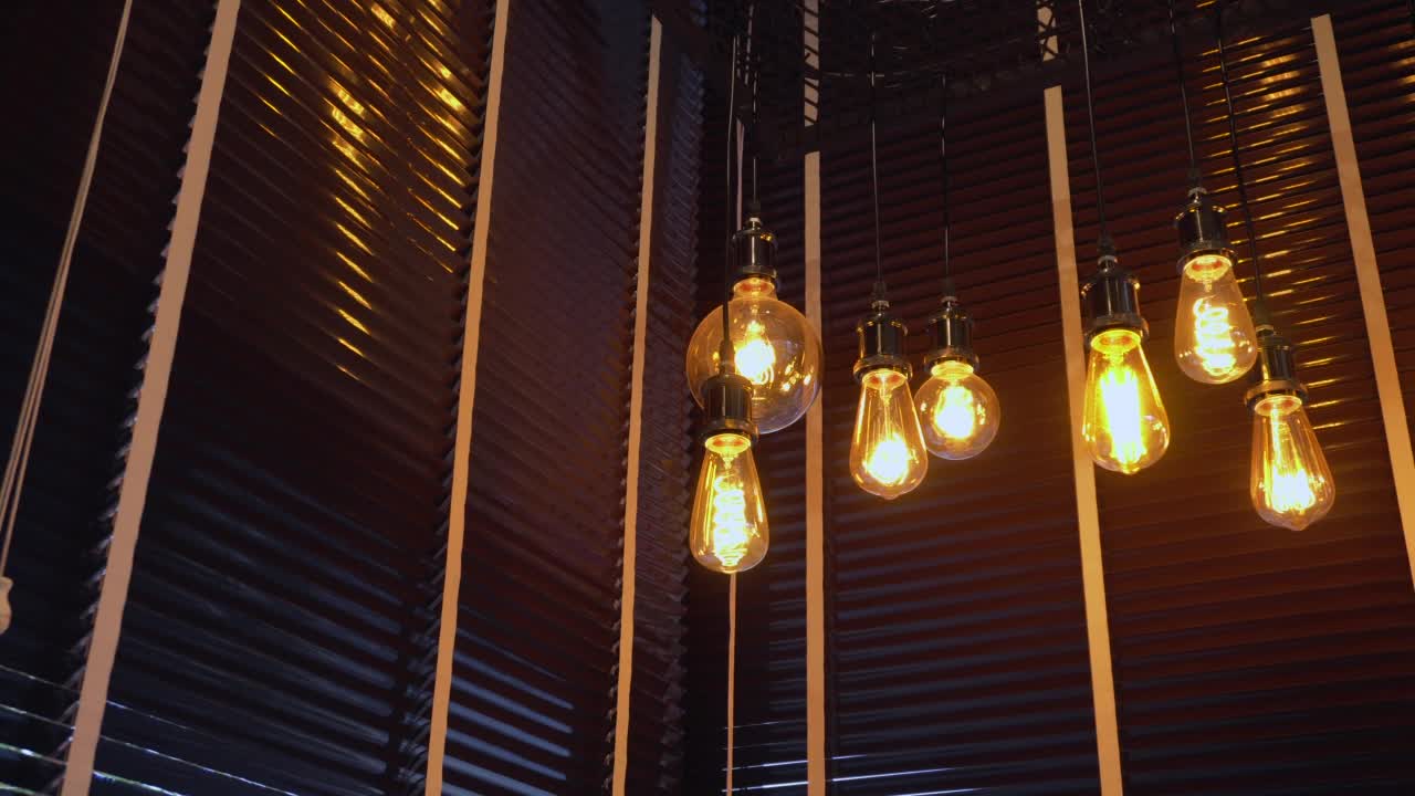 装饰古色古香的爱迪生式灯丝灯泡挂在天花板上的咖啡馆小酒馆和餐厅。视频素材