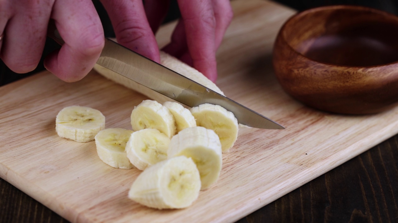 在木板上切一根黄熟的香蕉视频素材