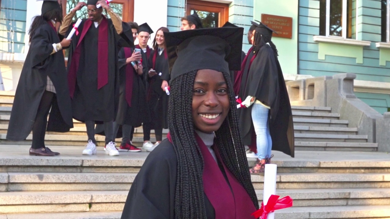 一个微笑的女毕业生拿着她的文凭的肖像视频素材