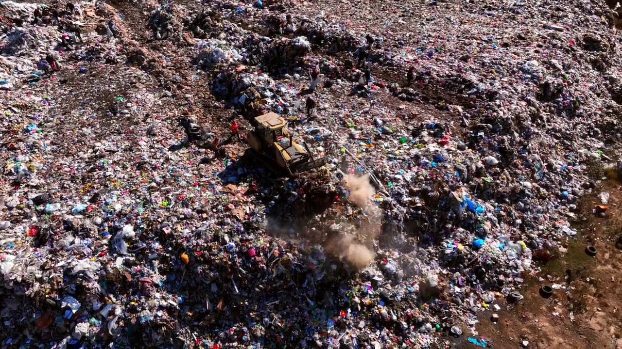 推土机在垃圾场与废旧塑料和聚乙烯。环境污染。视频素材