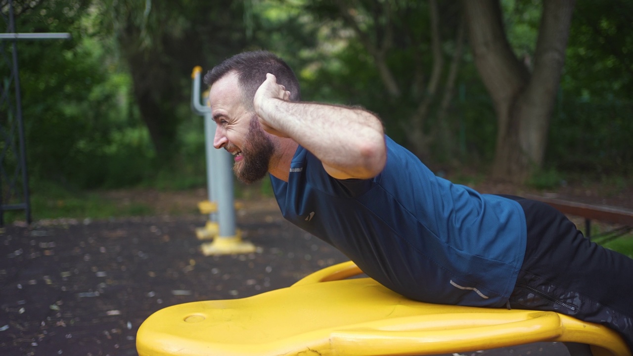 男运动员在公园里做背部锻炼视频下载