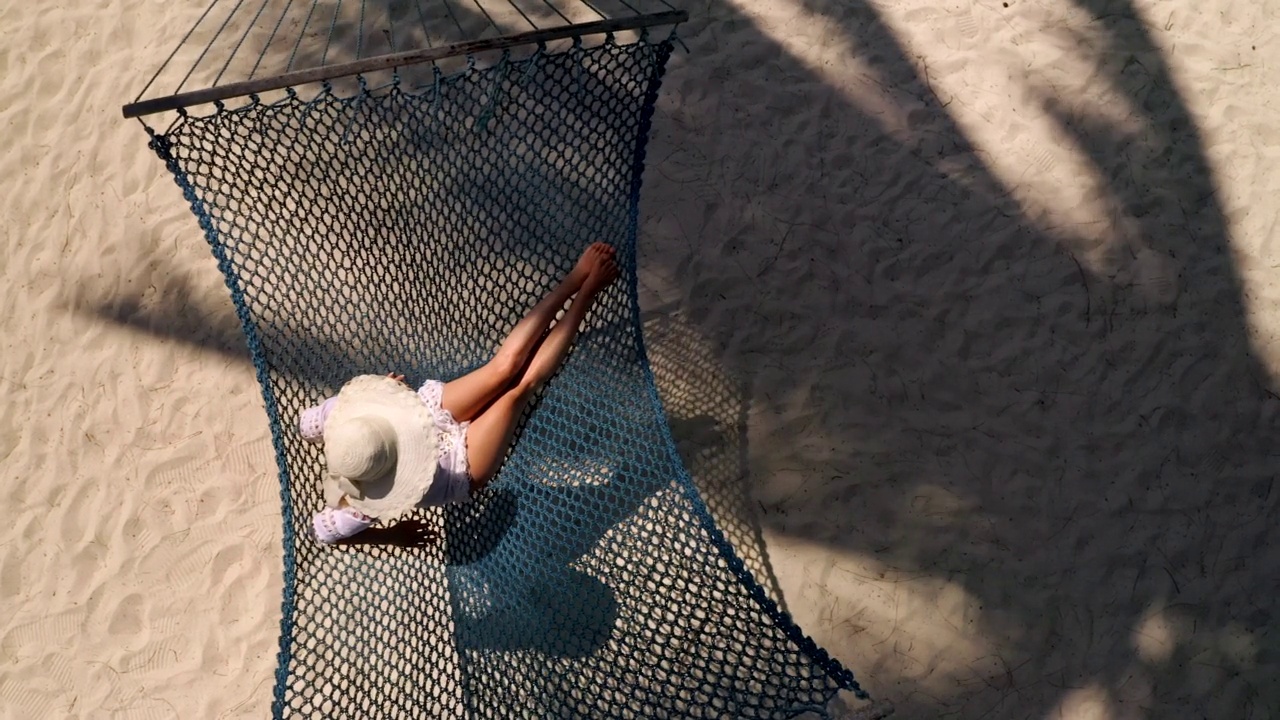 上面的观点放松的女人吊床上的海滩视频素材