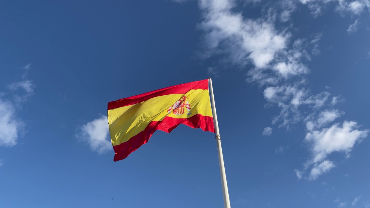 桅杆上飘扬的西班牙王国旗帜;红、黄、盾、冠，蓝天为背景;欧盟国家，也象征西班牙语和拉丁国家视频素材