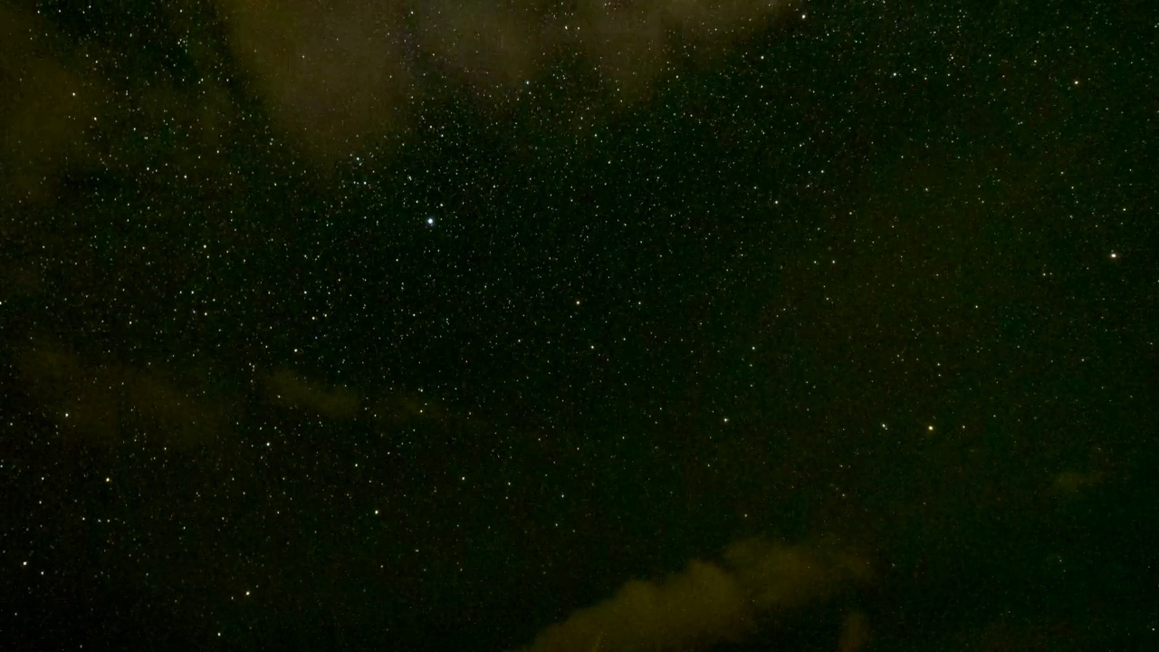 当高速云穿过天空时，在海洋上旋转的星星的时间流逝。视频下载