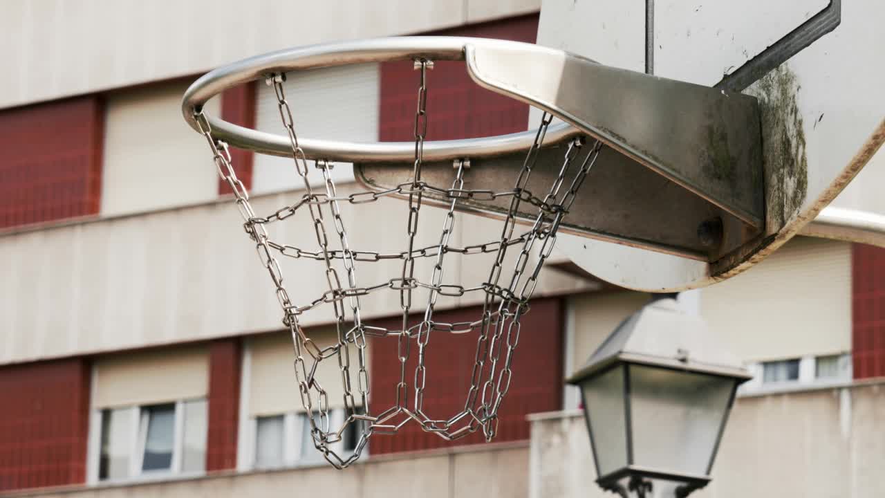 户外操场上的带金属链篮筐的篮球框视频下载