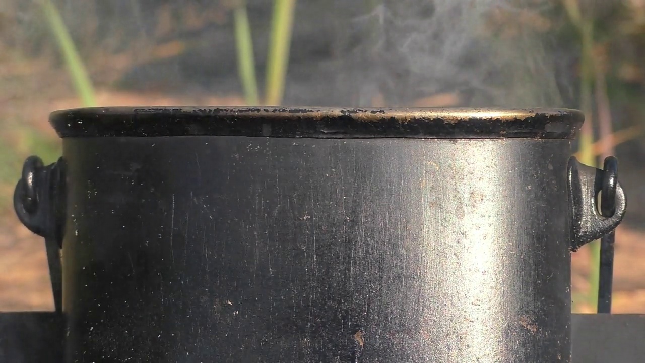 一个装有水的野营锅正在火上沸腾。视频素材