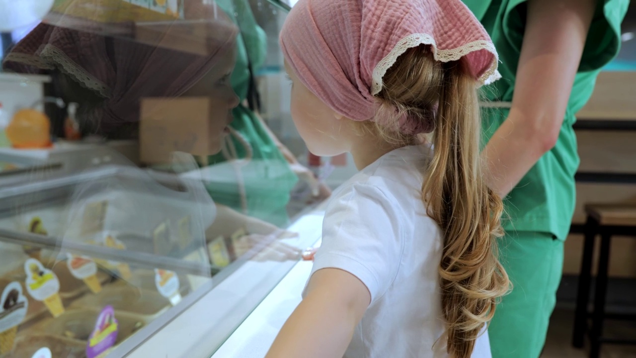 可爱的小女孩在咖啡馆里选择冰淇淋视频素材
