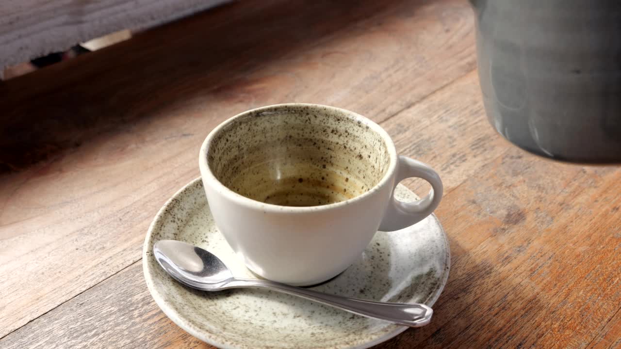 热绿茶倒入陶瓷杯，近景慢动作镜头视频素材