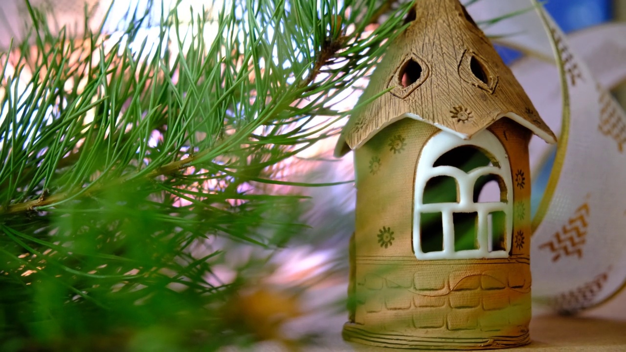 圣诞玩具屋和天然的杉木树枝，模糊的壁炉背景。新年和圣诞节的概念。改变焦点视频素材