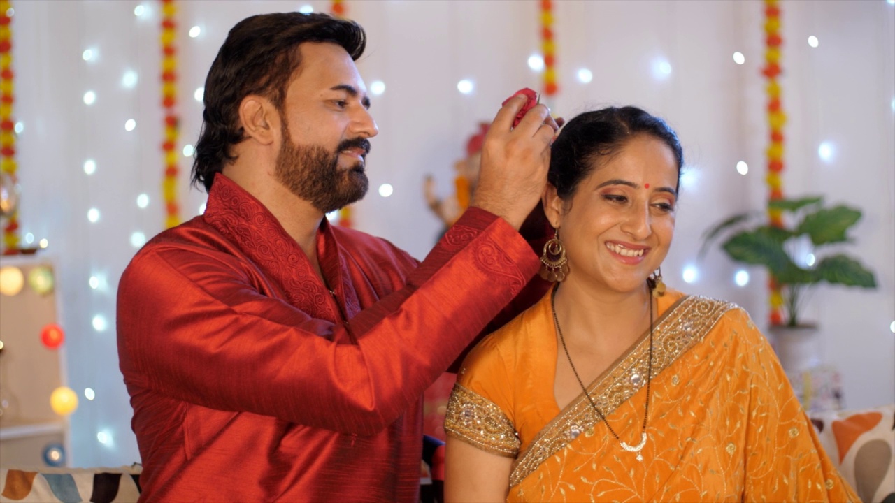 中年印度夫妇浪漫-在妻子的头发上插一朵玫瑰，节日的气氛，浪漫的夫妇视频素材