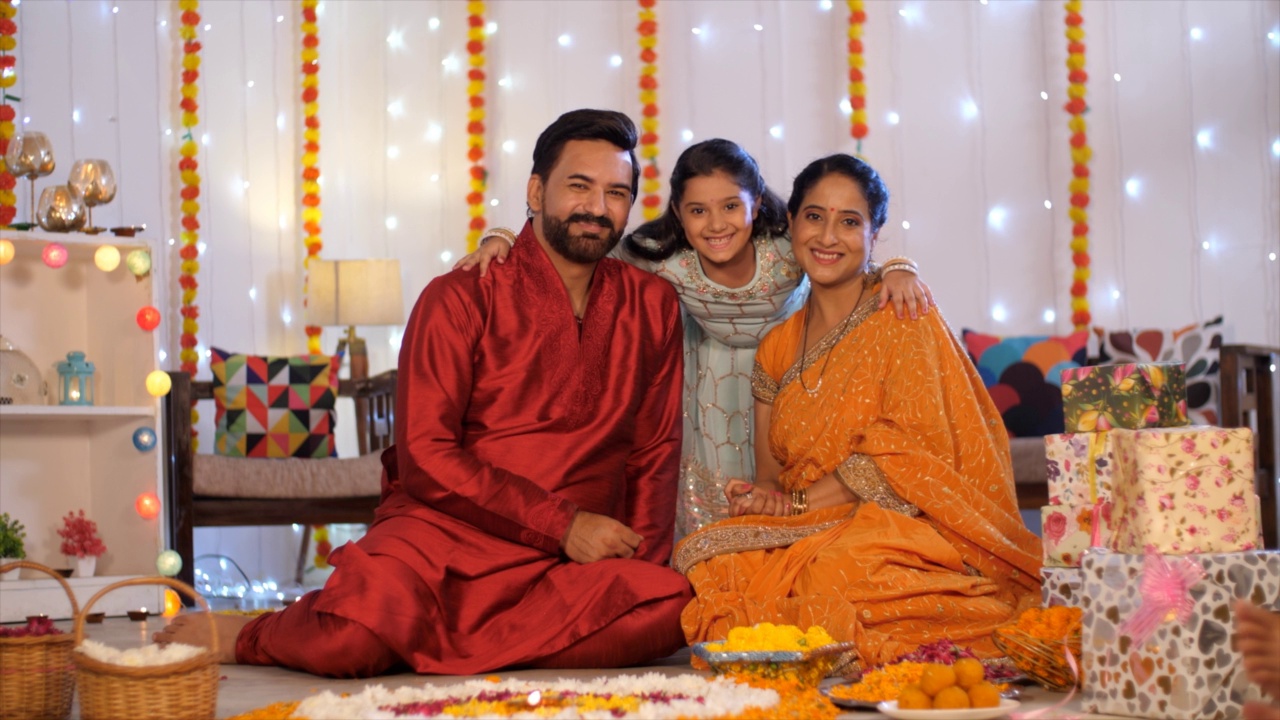 一个快乐的女孩拥抱她的父母-印度夫妇，印度的家，印度家庭摆姿势的镜头，排灯节装饰，节日背景视频素材