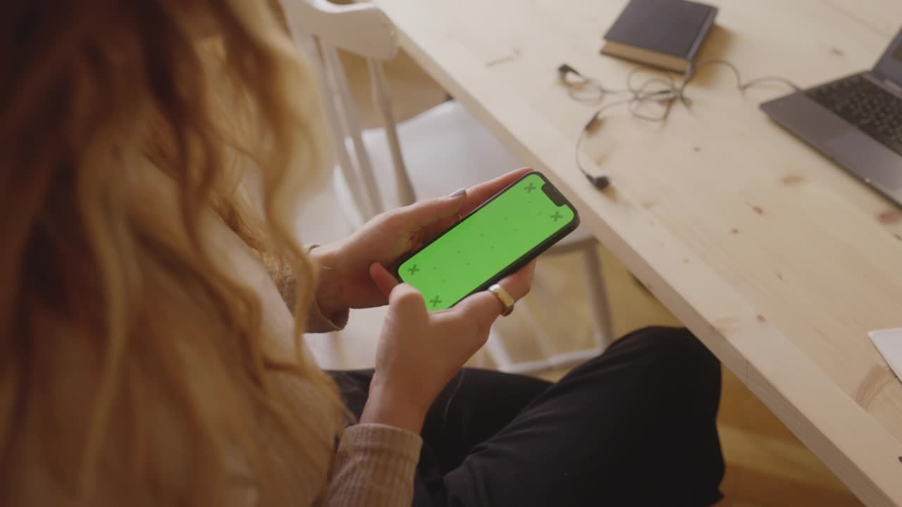 一名妇女在家里使用她的智能手机——有色度键视频素材