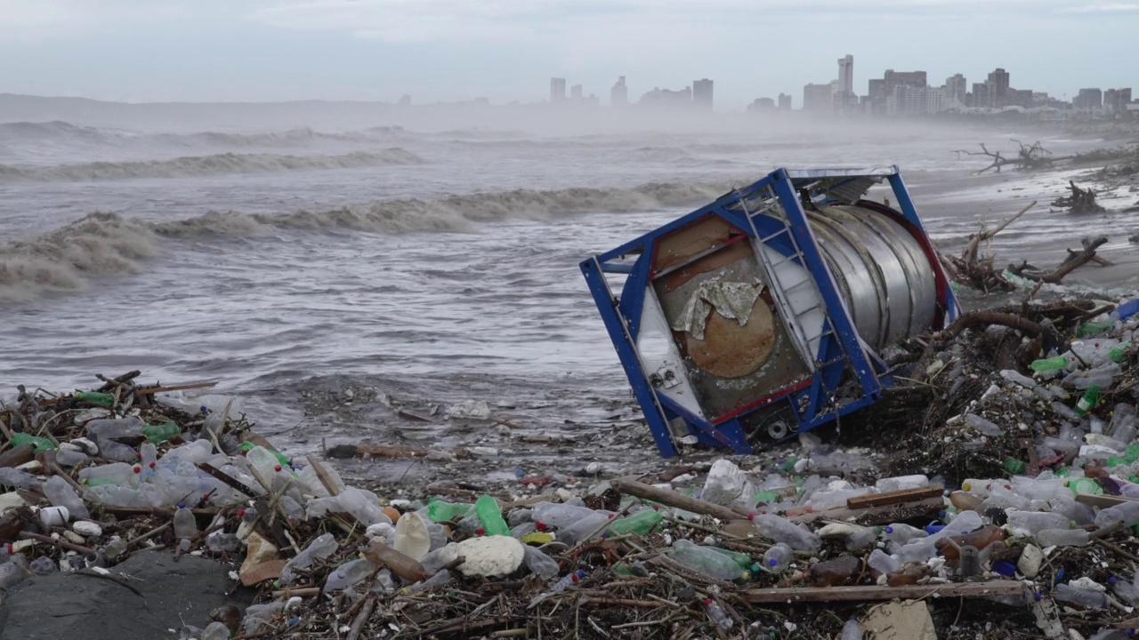 毁灭性的风暴过后，海滩上满是塑料污染和一艘冲毁的油轮。视频素材