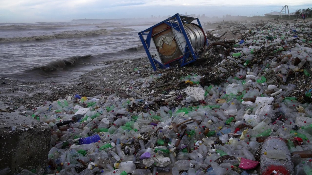 一处被塑料污染的海滩和一艘巨型油轮遭受了严重的风暴破坏。视频素材
