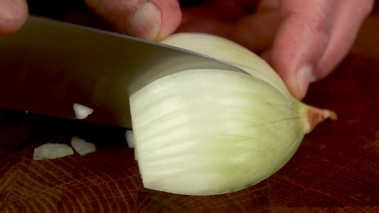 家用厨房用锋利的刀将白洋葱切成细丝。视频素材