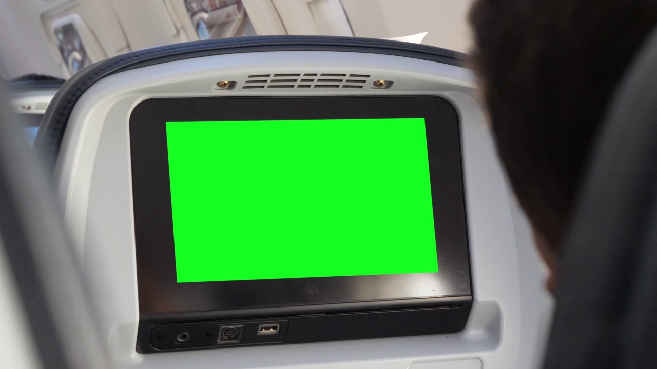 在长途大型飞机的座位娱乐系统中使用4K绿屏色度键，针对消费者、飞机购物者、通勤者、乘客和游客投放广告。从乘客的肩膀上看视频下载