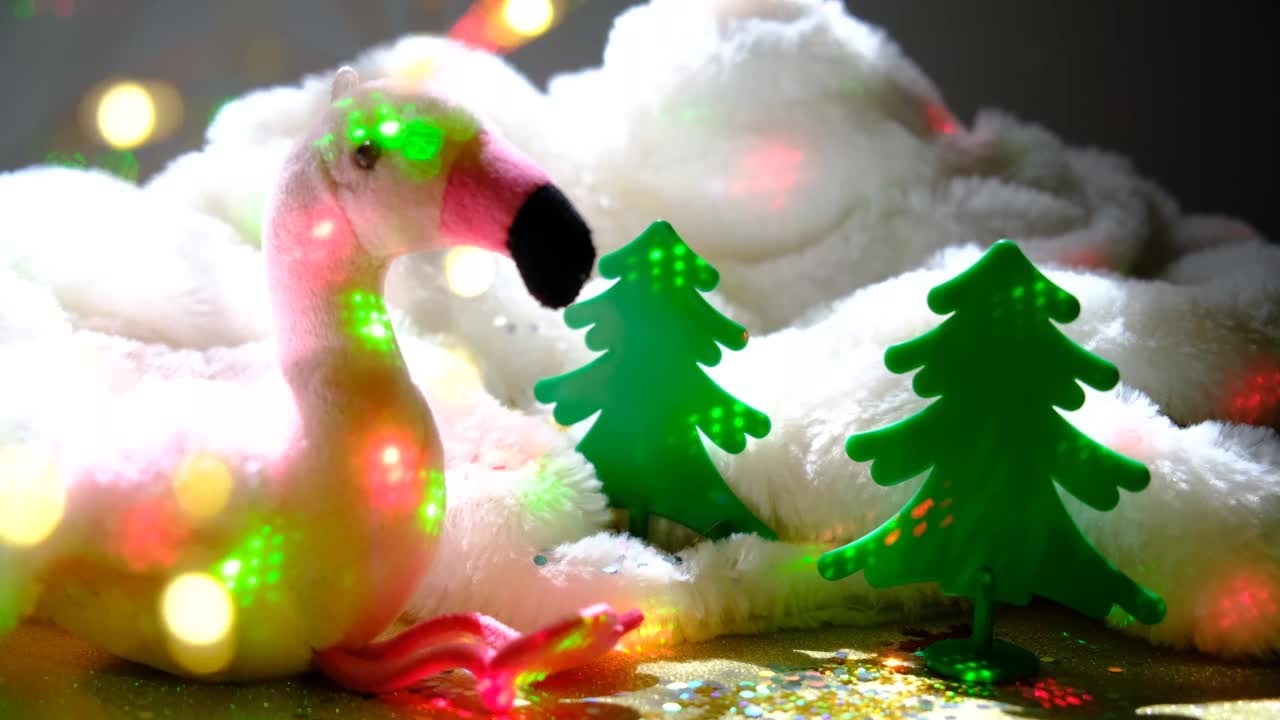 冬季仙女节日背景。有可爱玩具的圣诞气氛。粉红火烈鸟毛绒玩具。闪烁的灯光视频素材
