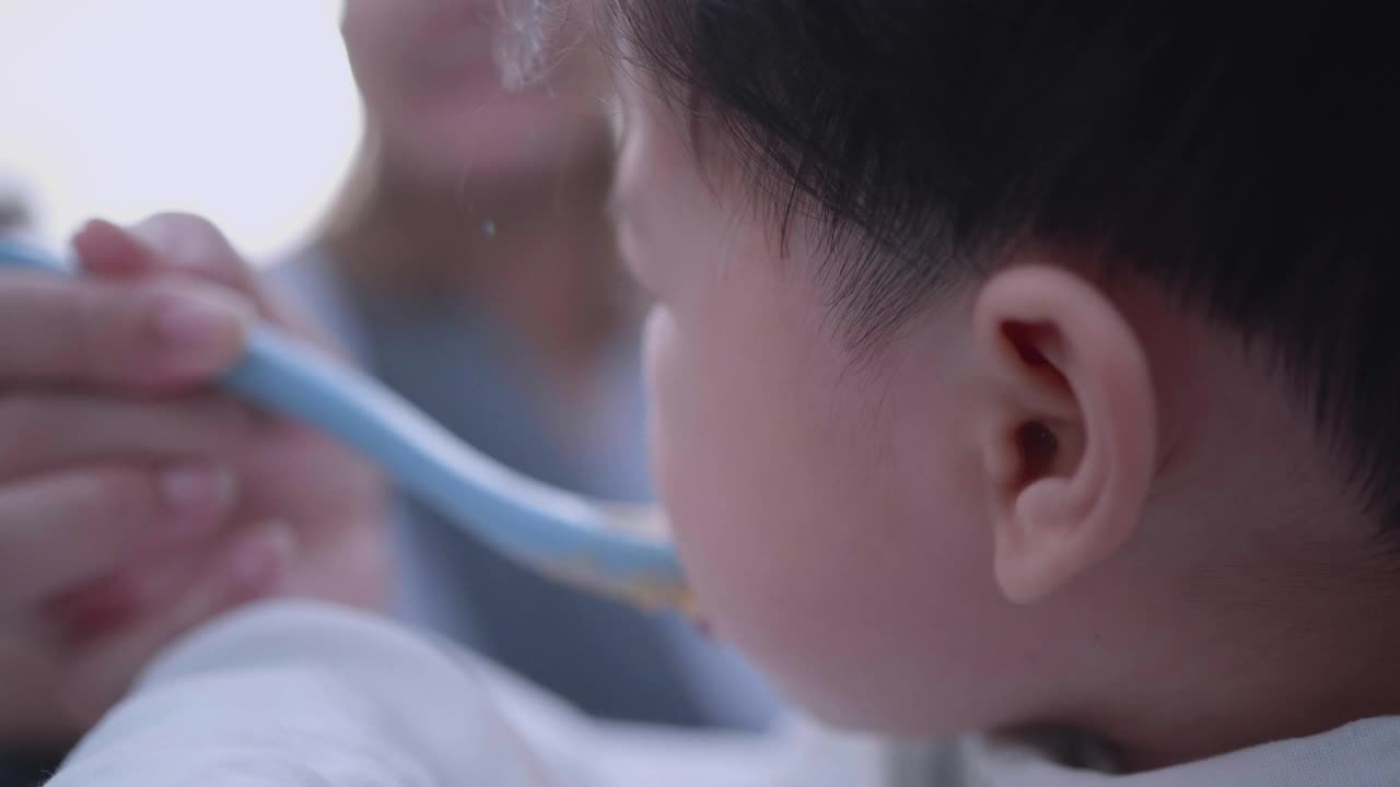 亚洲可爱的小男孩在家里户外的椅子上吃东西。视频素材