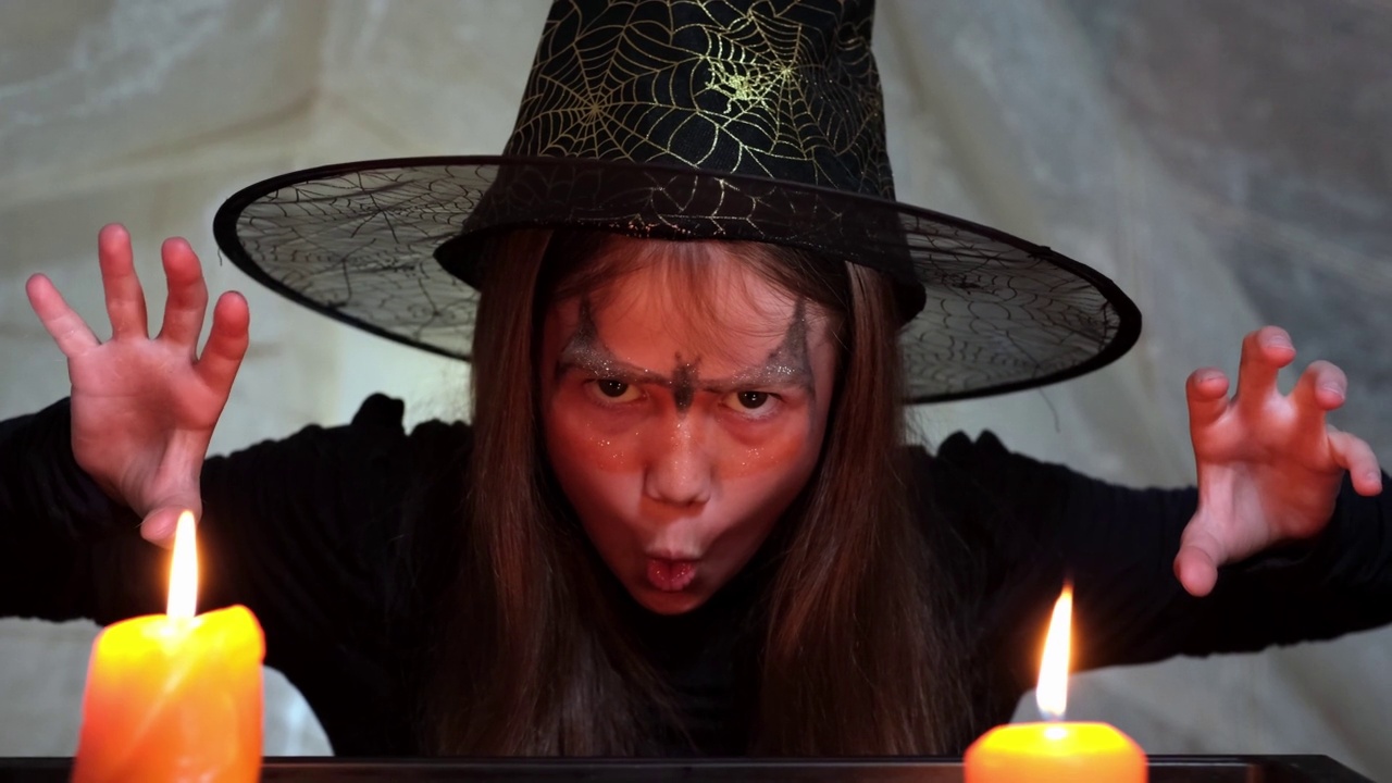 万圣节快乐。可怕的小女巫晚上拿着蜡烛说嘘视频素材