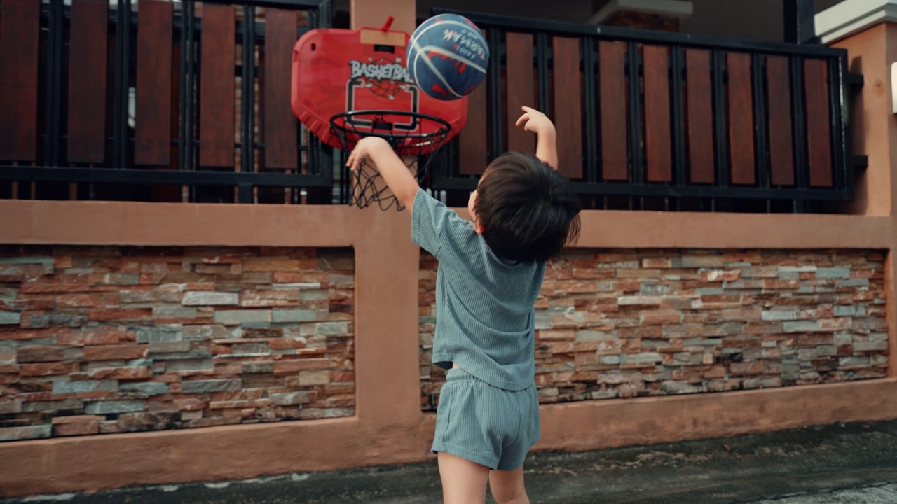 亚洲学步男孩在家门口打篮球视频下载