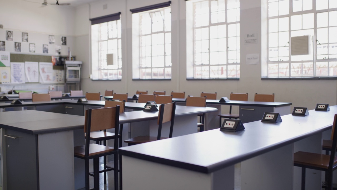 现代学校、学院或校园大楼因新冠肺炎关闭，教室里空着课桌、桌子和椅子。知识学习、学术教与学的内部教育视频下载