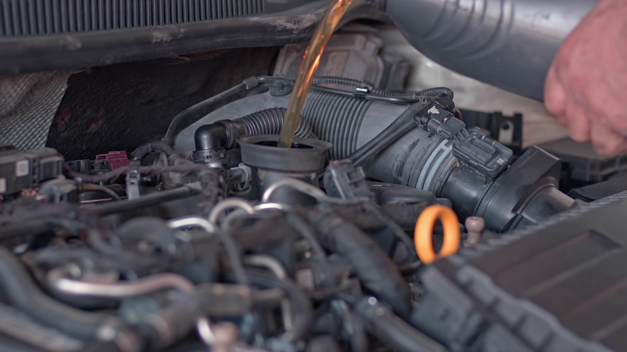 汽车发动机维修从黑瓶注入新的矿物油视频素材